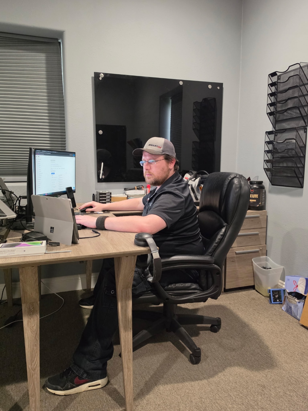 SmartIT technician working at a desk with a Microsoft Surface and external monitor