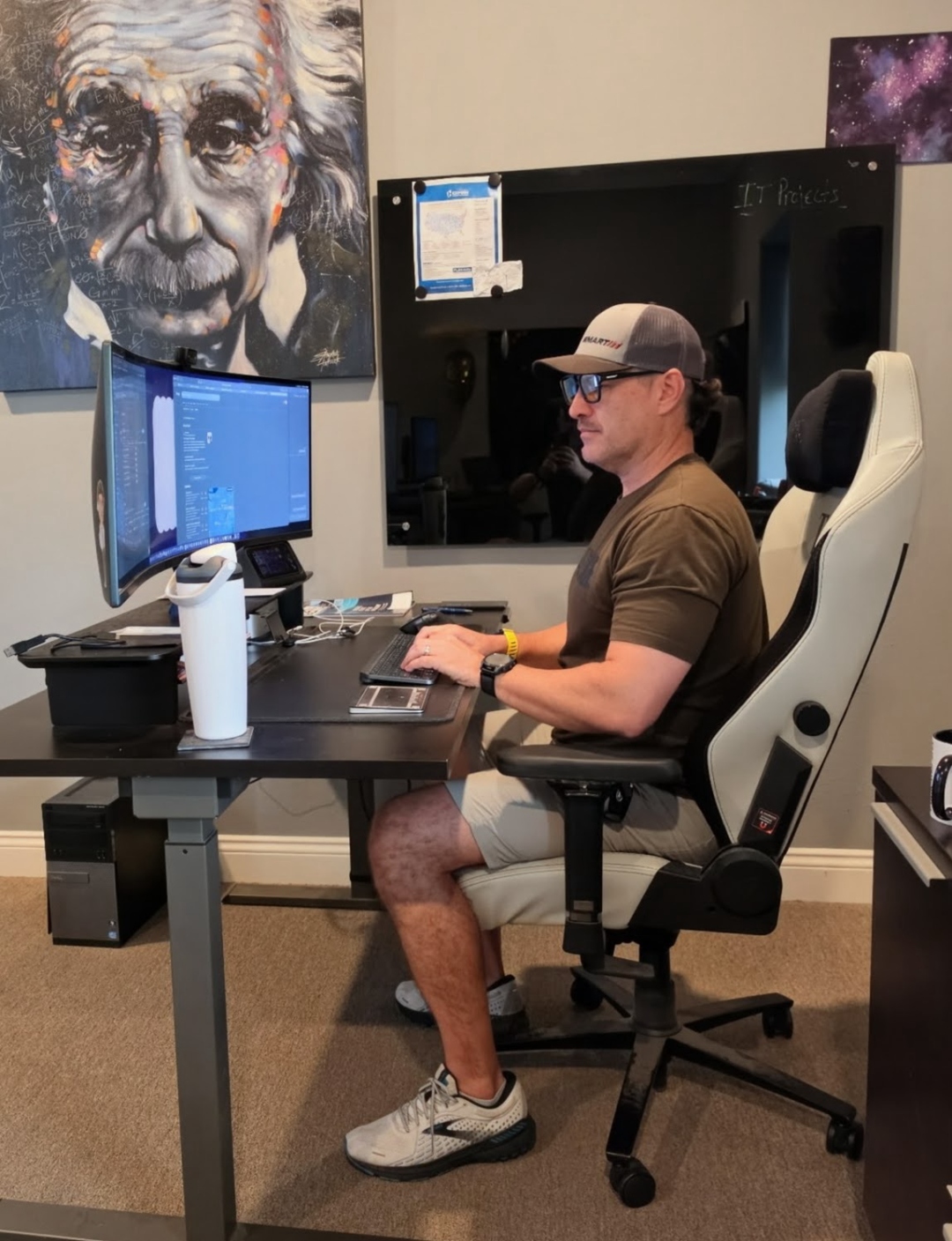 SmartIT technician working at a standing desk with dual monitors, reviewing IT project plans
