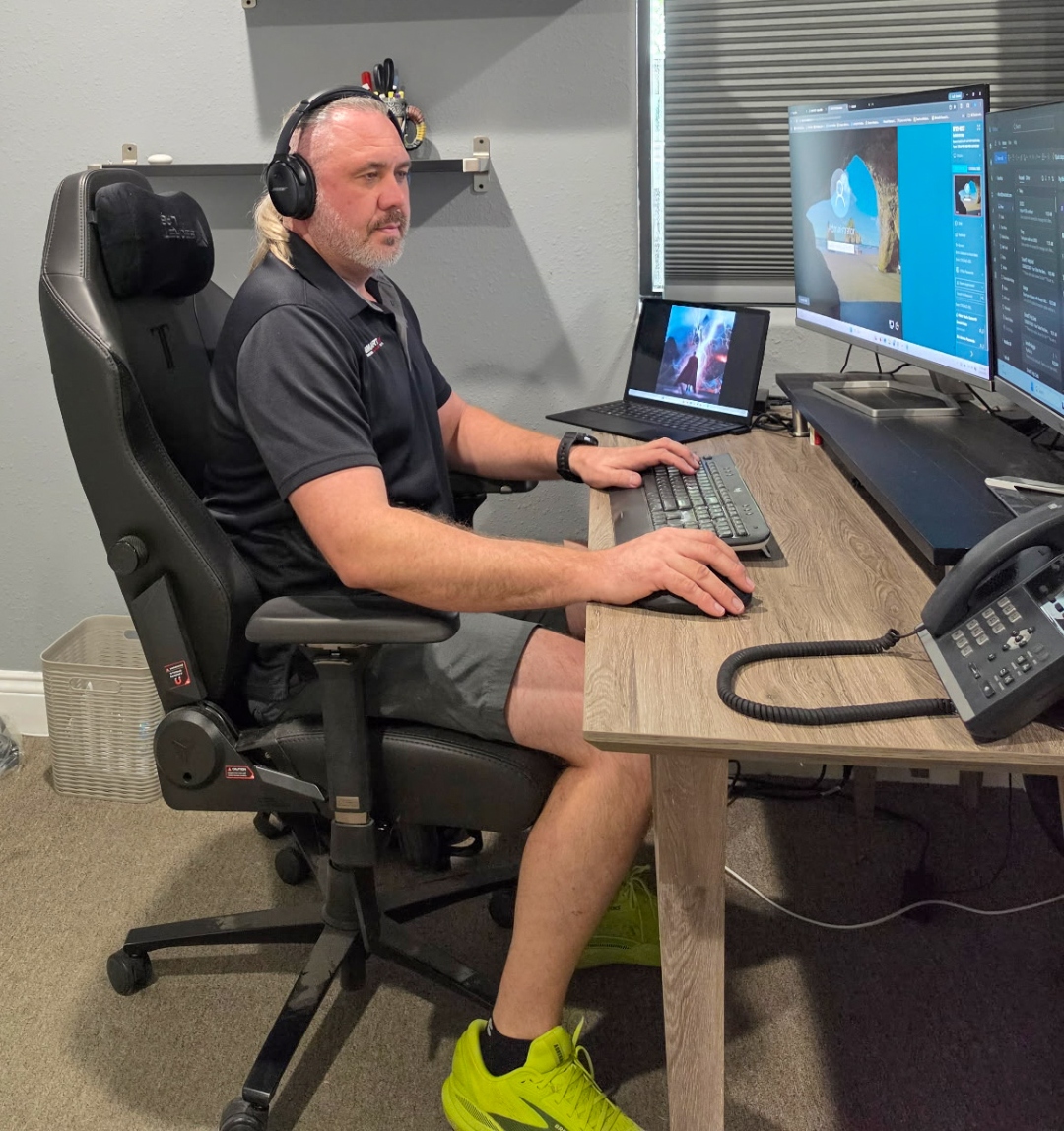 SmartIT technician with headphones managing multi-monitor workstation